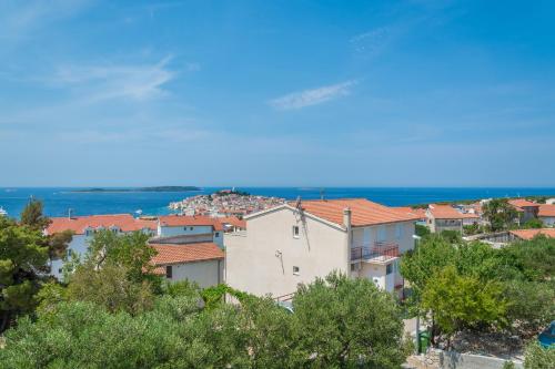 a group of houses on a hill with trees at Olive gardens in Primošten