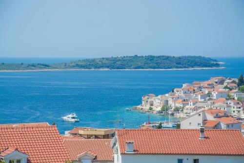 a view of a town with a boat in the water at Olive gardens in Primošten