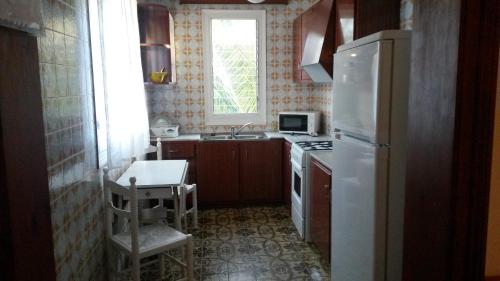 a kitchen with a white refrigerator and a sink at Las Belisas in Arenal d'en Castell