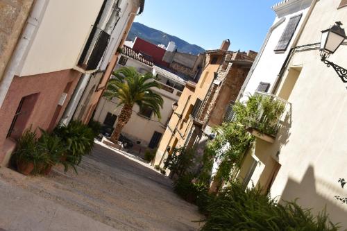 um beco com uma palmeira e edifícios em La Casassa em Les Coves de Vinroma