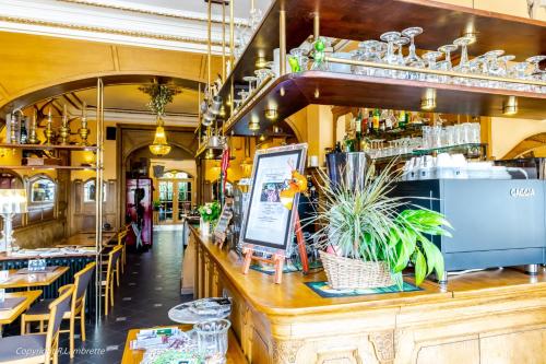 un restaurante con un bar con plantas en el mostrador en Hotel Des Ardennes, en Verviers