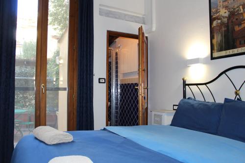 a bedroom with a blue bed and a window at Gmax Guelfa Apartments in Florence