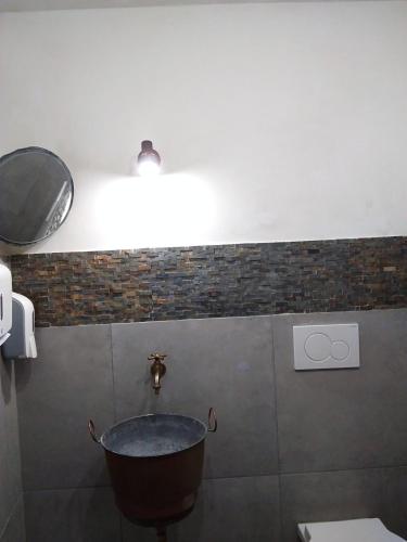 a bathroom with a tub and a toilet and a light at Lucernaio Rooms in Ragusa