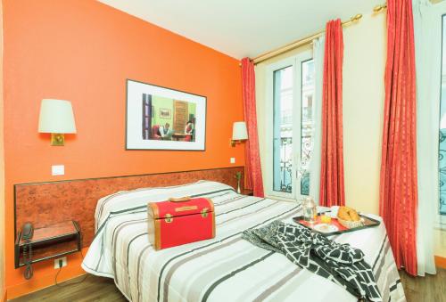 una camera d'albergo con un letto con una valigia rossa sopra di Hotel Pierre Nicole a Parigi
