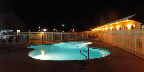 a swimming pool at night next to a fence at Sea Esta Motel II in Long Neck