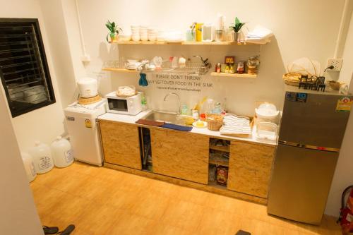a kitchen with a sink and a microwave at Khoksametchun Hostel in Hat Yai
