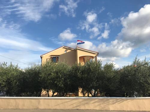 ein Gebäude mit einer Flagge darüber in der Unterkunft Apartmani Lavanda in Vrsi