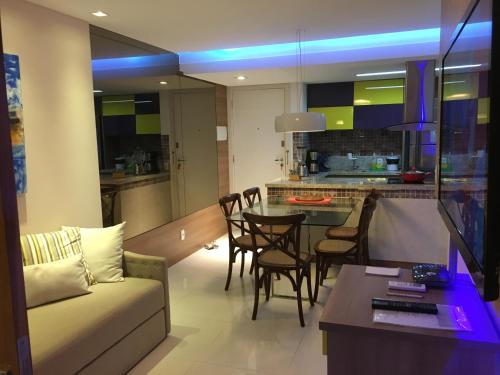 een woonkamer en een keuken met een bank en een tafel bij In Mare Bali Resort 127 in Parnamirim