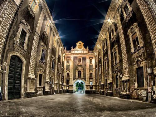 een oud gebouw met 's nachts een lege straat bij Duomo Bed & Breakfast in Catania