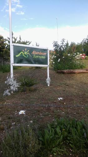 a sign in the middle of a field at Atardecer Serrano in Huerta Grande