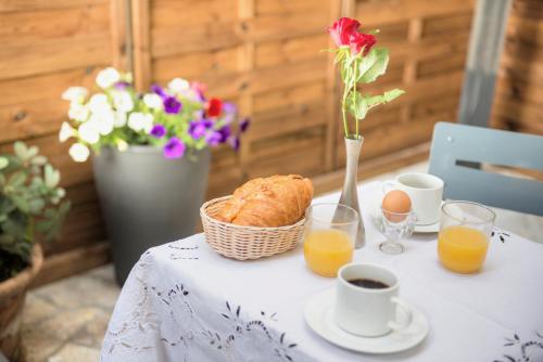 Una mesa con una cesta de pan y zumo de naranja. en Hotel Pierre Nicole, en París