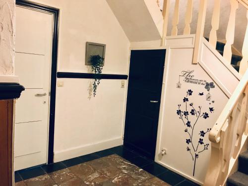 a hallway with a staircase with a door and a stairwell at Gite Le Cerf Pantin in Saint-Hubert