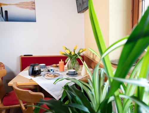 a dining room table with a vase of flowers on it at Haus Marianne in Sankt Jakob in Defereggen