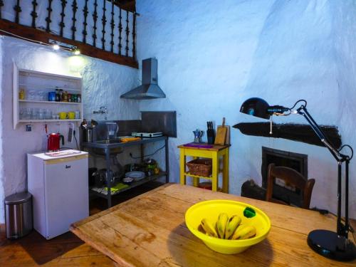 a kitchen with a bowl of bananas on a wooden table at casa limon, El Guro in Valle Gran Rey