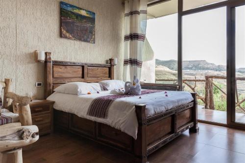 a bedroom with a bed with a stuffed animal on it at Sora Lodge Lalibela in Lalībela
