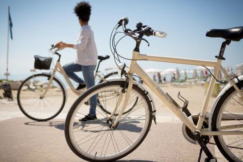 a woman walking two bikes on the beach at Hotel Marco Polo in Caorle