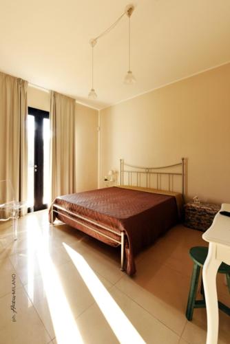 a bedroom with a bed in a room with a piano at La Casa di Flò Luxury Rooms in Alezio