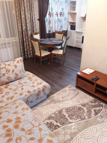 ein Wohnzimmer mit einem Sofa und einem Esstisch in der Unterkunft Apartments on 23,1 Nаzarbaeva Ave in Öskemen