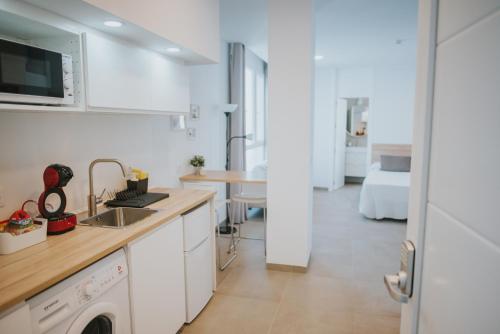 una cocina con fregadero y lavadora en Apartamentos ZHR, en Zahara de los Atunes