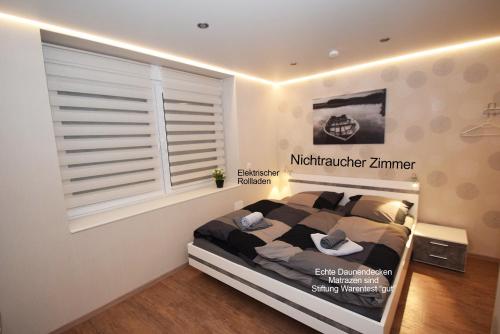 a bedroom with a bed and a window with blinds at Ferienzimmer Saarlouis in Saarlouis