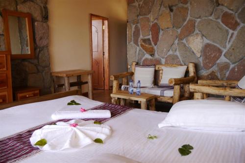 a bedroom with two beds and a stone wall at Sora Lodge Lalibela in Lalībela