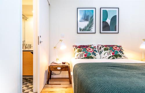 sypialnia z łóżkiem i 3 zdjęciami na ścianie w obiekcie The Foz Garden Studio w Porto