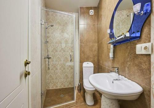 a bathroom with a sink and a toilet and a shower at Hotel Pushkin in Tbilisi City