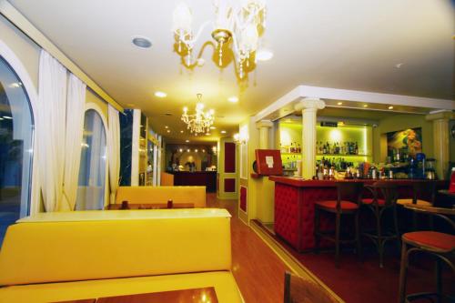 restauracja z barem i żółtą ławką w obiekcie Seaside Hotel w mieście Lutraki