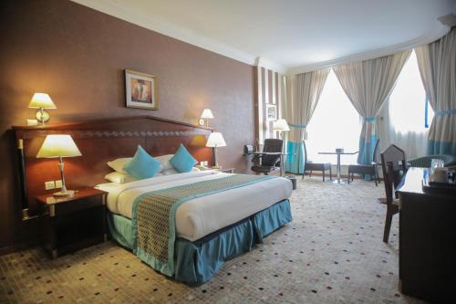 a hotel room with a large bed and a desk at Qasr Al Sahab in Khamis Mushayt