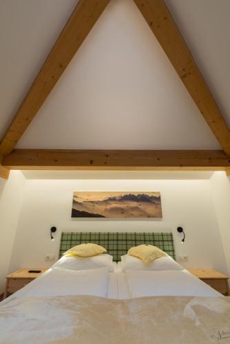 a bedroom with two white beds in a attic at Berghotel Johanneshof in Anterselva di Mezzo