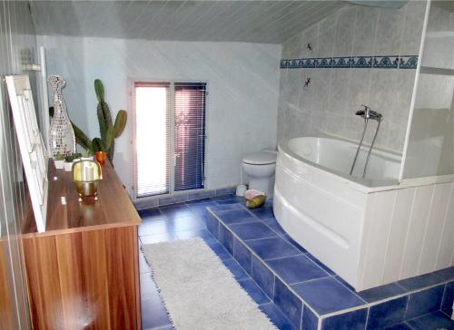 Łazienka z wanną i niebieską podłogą wyłożoną kafelkami w obiekcie Appartement de charme Arles-sur-Tech(66) w mieście Arles-sur-Tech
