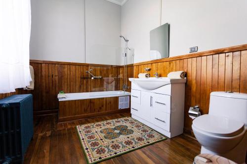 a bathroom with a tub and a sink and a toilet at Hotel Estancia Caleta Josefina in Onaisin