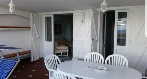 a dining room with a white table and white chairs at La Maison de Leo in Massa Lubrense