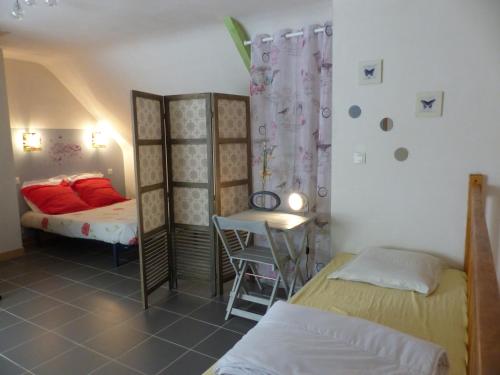 a bedroom with two beds and a table and a chair at Coqueno in Sarzeau