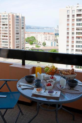 une table avec de la nourriture au sommet d'un balcon dans l'établissement Résidence les Ibis Location entre mer et montagne, à Toulon