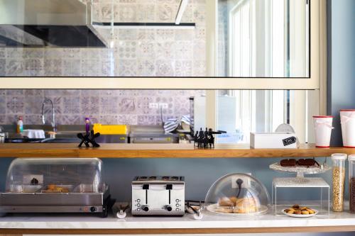a kitchen with a counter with some food on a shelf at Bel Ami Suita Hotel in Vlorë