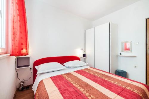 Schlafzimmer mit einem roten Bett und einem TV in der Unterkunft VELA in Sevid