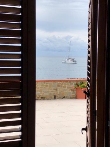 a sailboat in the ocean with a boat in the water at La Terrazza nel Mare in Acciaroli