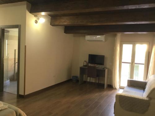 a living room with a couch and a tv and a window at B&B Nonna Maria in Lamezia Terme