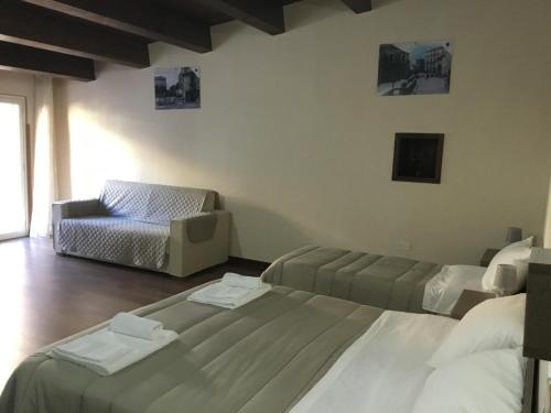 a hotel room with two beds and a couch at B&B Nonna Maria in Lamezia Terme