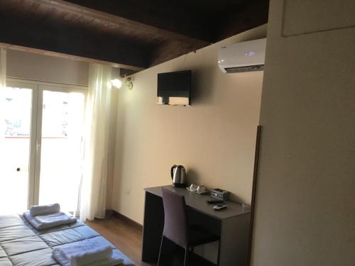 a room with a desk and a bed and a television at B&B Nonna Maria in Lamezia Terme