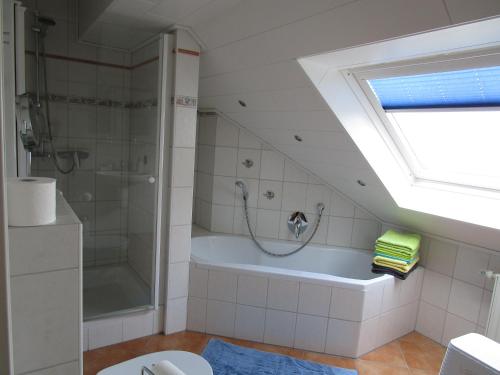 a bathroom with a shower and a bath tub at Pension Kölzer in Mörsdorf