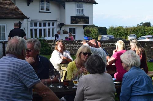 a group of people sitting at a table with wine glasses at The Plough Inn in Stalisfield