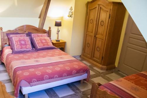 a bedroom with two beds and a wooden cabinet at B & B - Chambre d'hôte entre Arras et Albert in Souastre