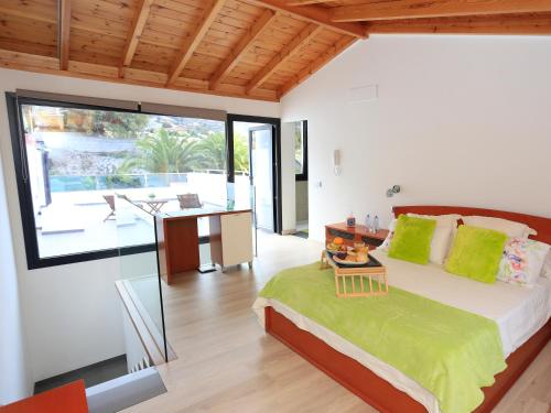 a bedroom with a large bed with a desk and a view at CASA BEATRIZ in La Orotava