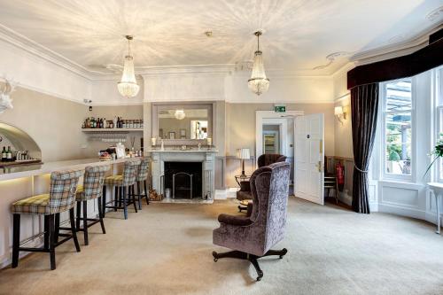 a living room with a bar and some chairs at Alexandra Court Hotel in Congleton