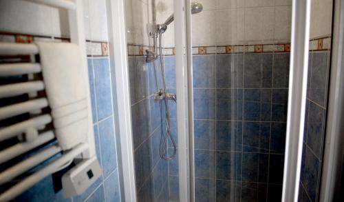 a shower in a bathroom with blue tiles at Work & Sleep in Piaseczno