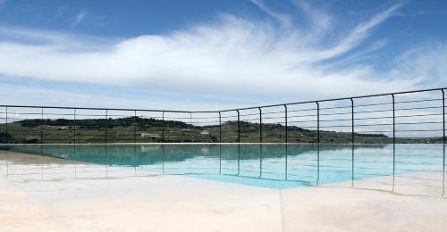 a swimming pool with a fence and water at Casa Sobrero in Castiglione Falletto