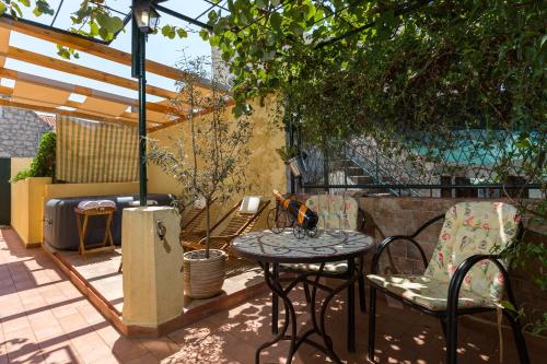 eine Terrasse mit einem Tisch und Stühlen unter einer Pergola in der Unterkunft Apartment Hladilo "Nostalgia" in Dubrovnik