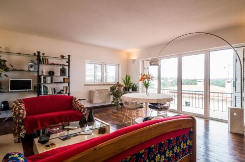 a living room with a red couch and a table at Leiria Fatima Nazaré 3 Bedroom House in Leiria